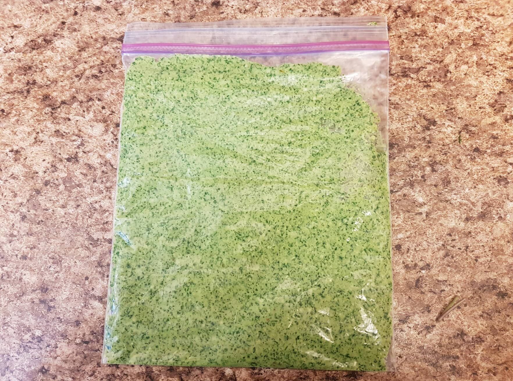 Image of pesto flat in a ziploc bag for freezing.