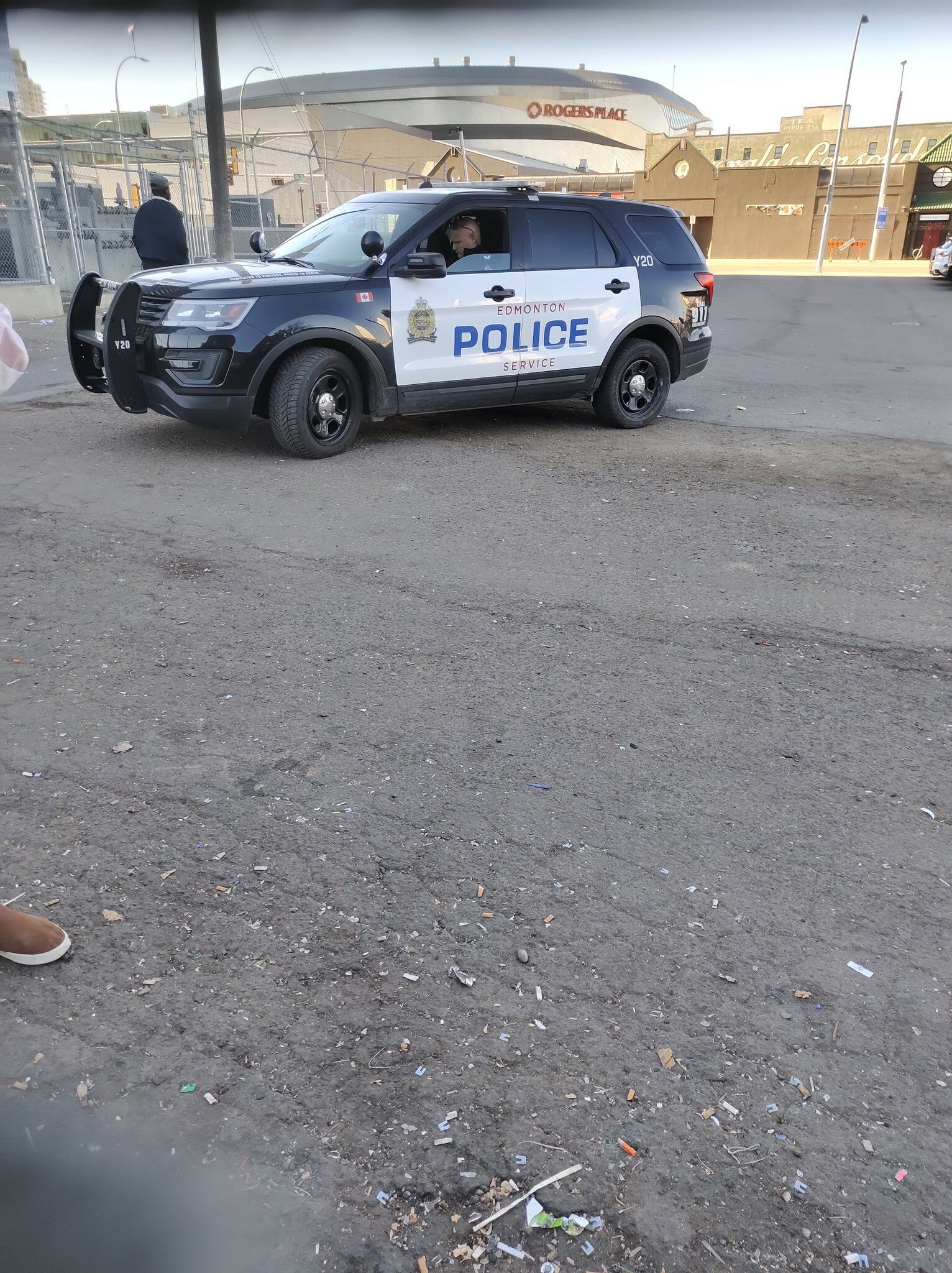 Cop sitting in his cop car, downtown, in an empty parking lot.